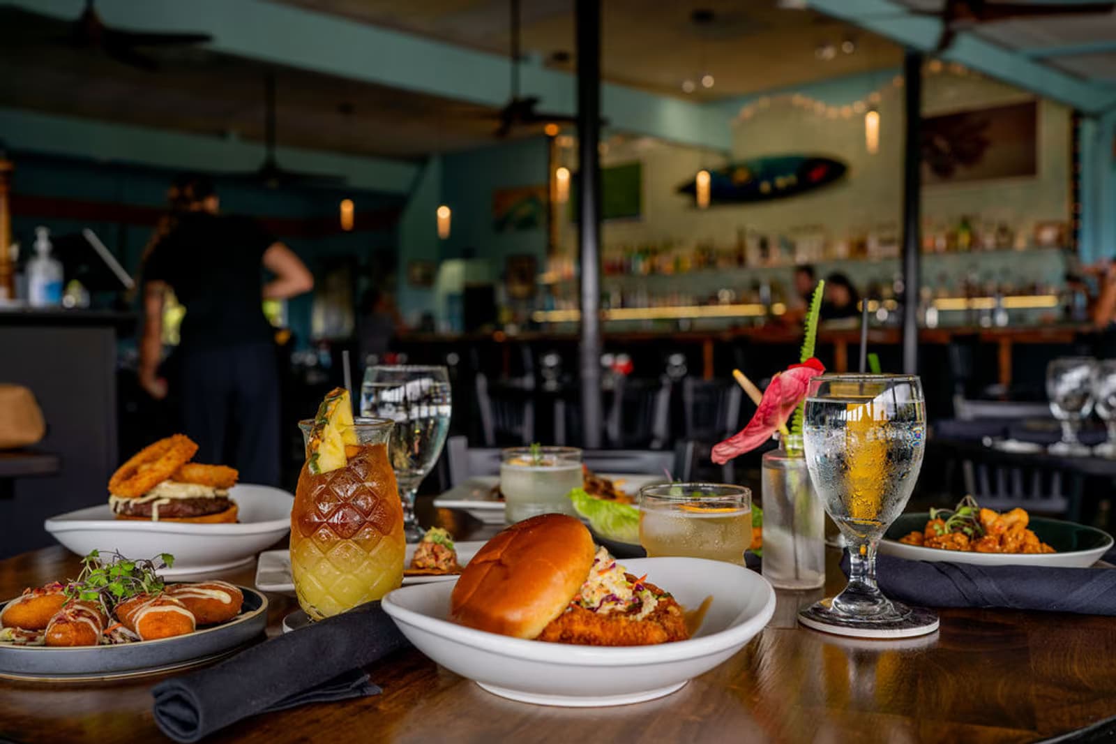 A full Jackie Rey's lunch spread with sliders, cocktails, and sides on a wooden table